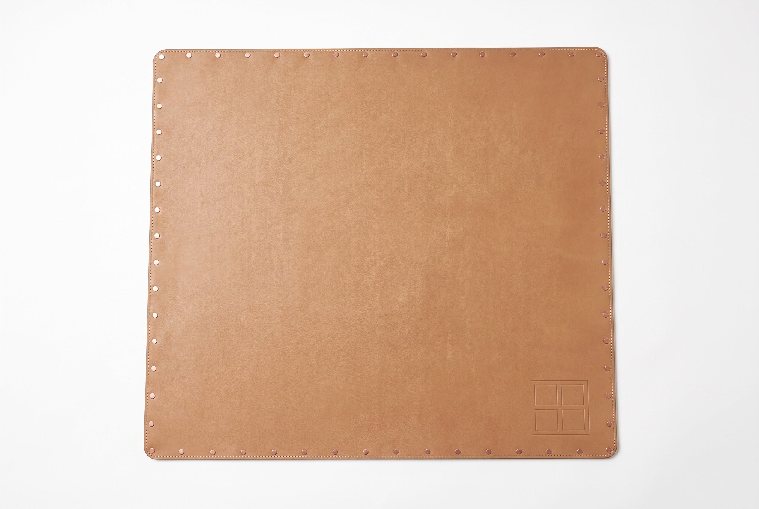 33-inch tan vegan leather game mat rolled with copper rivets and gold buckles.