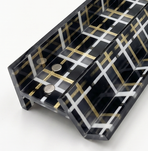 Black plaid mahjong rack with white and gold stripes holding four tiles