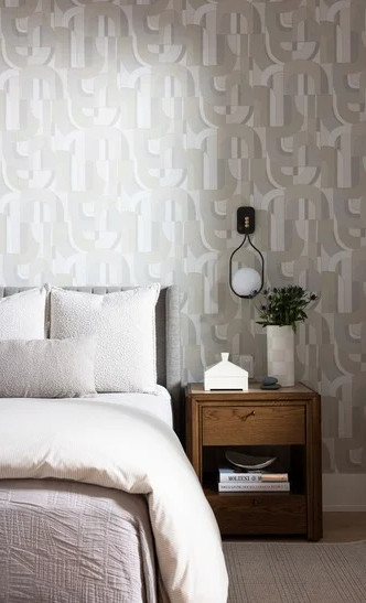 Bedroom with patterned wallpaper, walnut nightstand, cream linen bedding