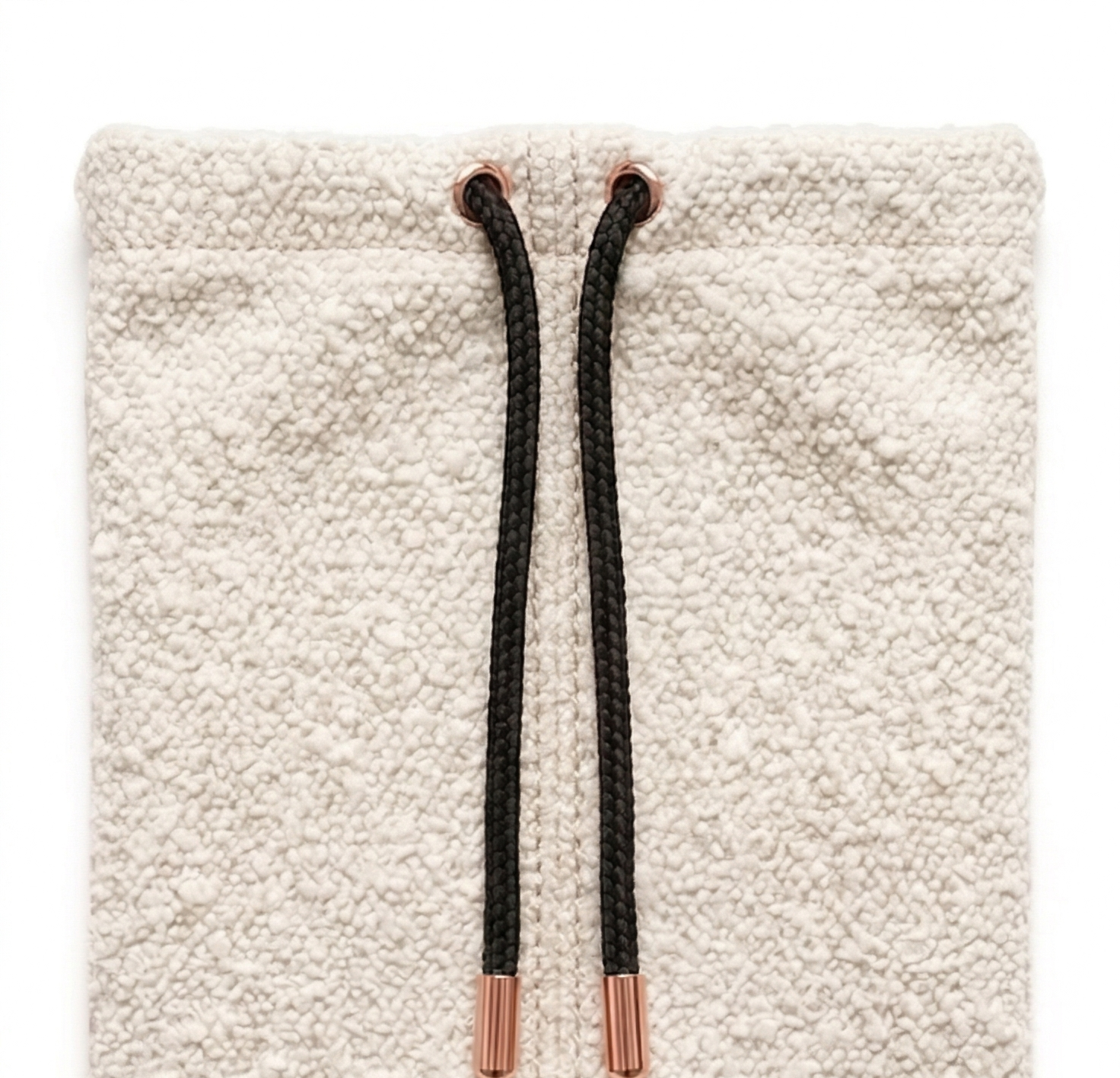 Ivory bouclé pouch with rose-gold drawstring tips on a neutral surface