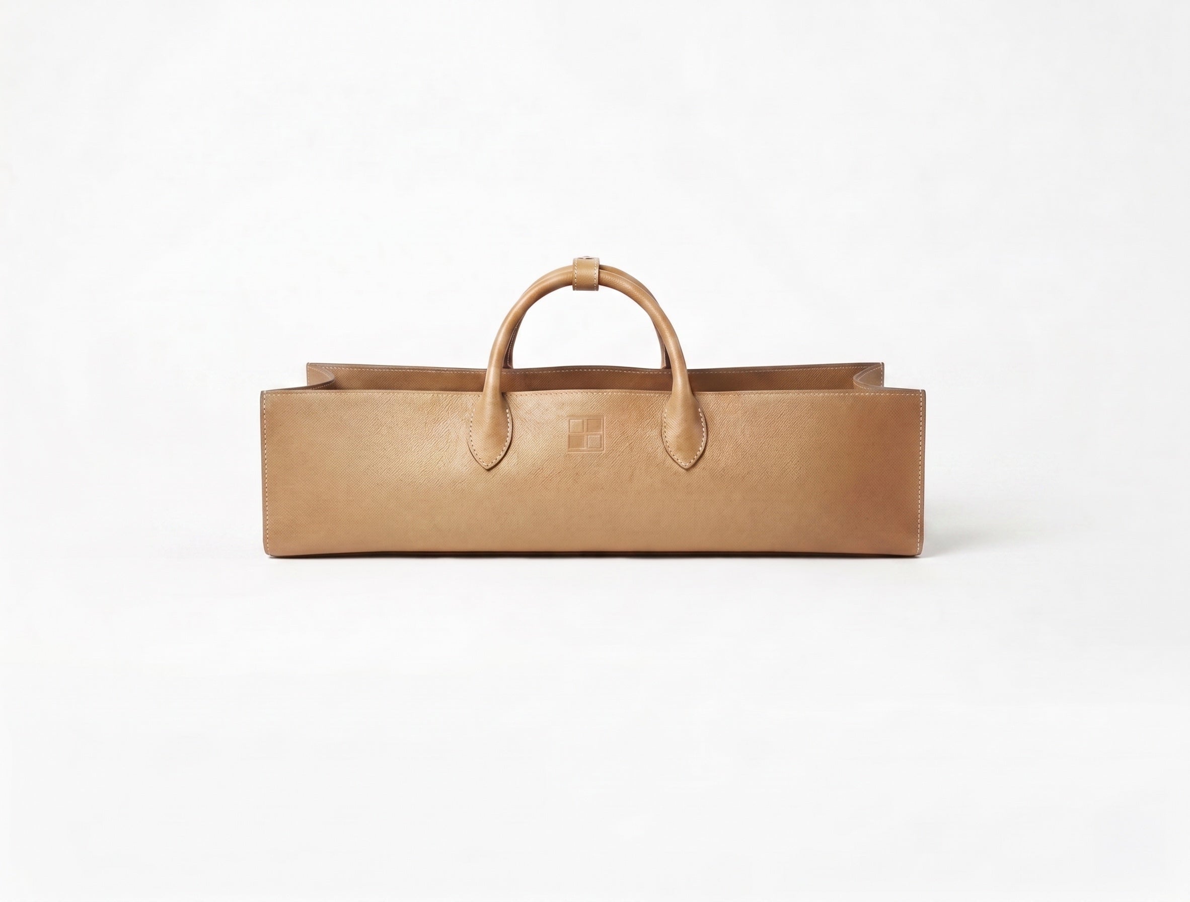 Tan vegan leather storage and travel tote with embossed Mise en Mahjong mark.